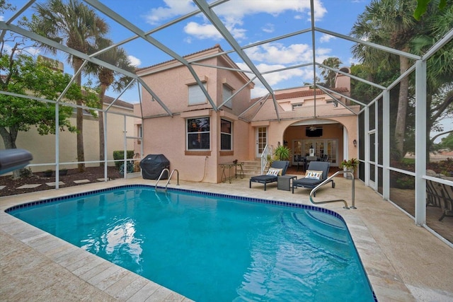 view of pool featuring a patio, glass enclosure, and grilling area