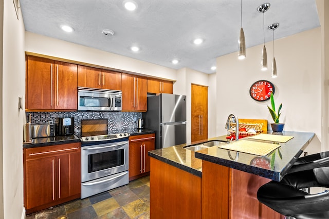 kitchen featuring sink, tasteful backsplash, decorative light fixtures, a breakfast bar area, and appliances with stainless steel finishes