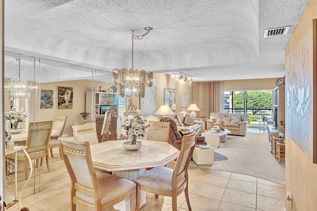 tiled dining space with a notable chandelier and a textured ceiling