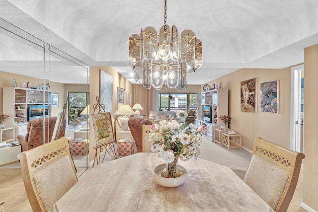 carpeted dining area with a notable chandelier and a textured ceiling