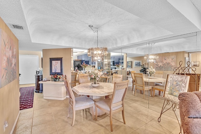 tiled dining space featuring a textured ceiling and a notable chandelier