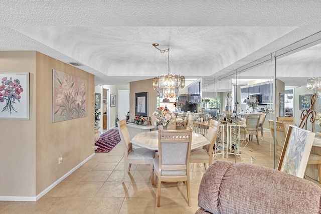 dining room featuring an inviting chandelier, light tile patterned floors, and a textured ceiling