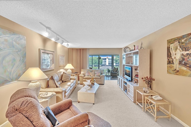 carpeted living room with a textured ceiling and rail lighting