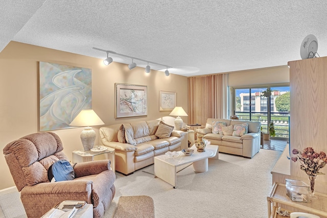 carpeted living room featuring a textured ceiling and rail lighting