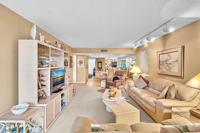 carpeted living room featuring a textured ceiling and rail lighting