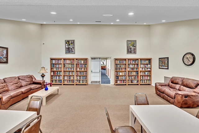 living room featuring a high ceiling, a textured ceiling, and carpet flooring