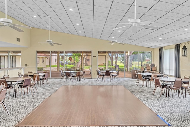 dining area featuring ceiling fan, hardwood / wood-style flooring, and a drop ceiling