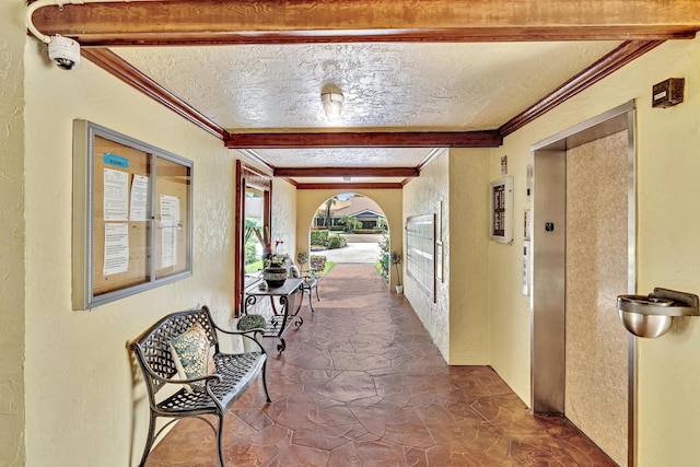 hallway featuring a textured ceiling, beam ceiling, and elevator