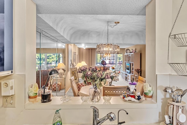 dining room with a notable chandelier, a textured ceiling, and a healthy amount of sunlight