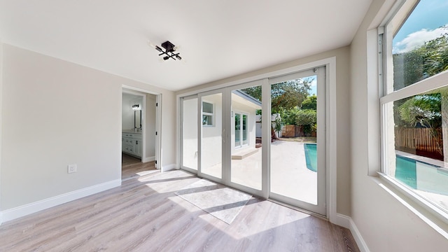 empty room with light hardwood / wood-style flooring and plenty of natural light