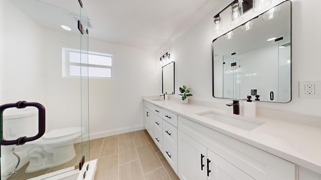 bathroom with tile patterned floors, a shower with door, vanity, and toilet