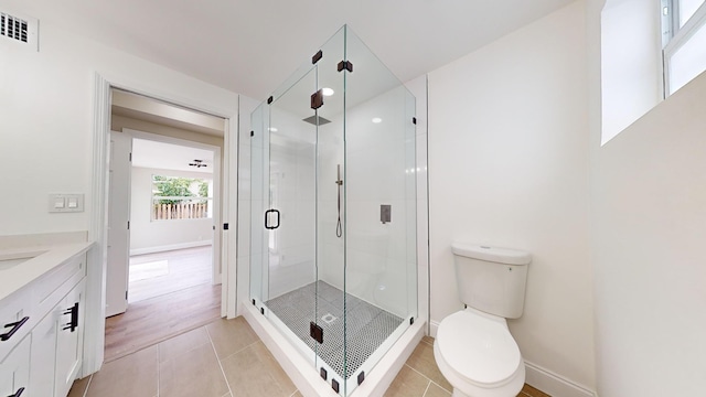 bathroom with vanity, a shower with shower door, toilet, and tile patterned floors