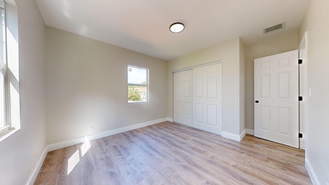 unfurnished bedroom featuring a closet and light hardwood / wood-style flooring