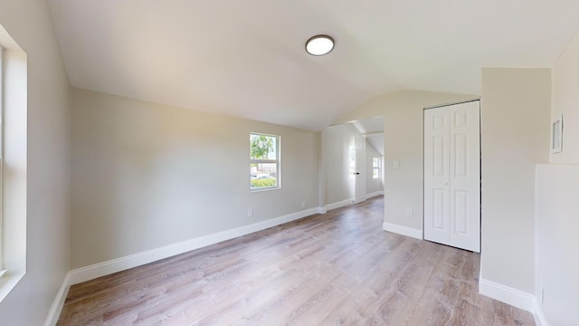 additional living space with vaulted ceiling and light hardwood / wood-style floors