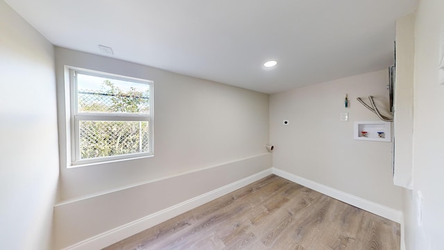 laundry room with hookup for a washing machine, light hardwood / wood-style floors, and electric dryer hookup