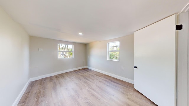 empty room with light wood-type flooring and plenty of natural light