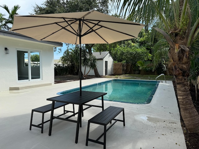 view of pool featuring a storage shed and a patio area