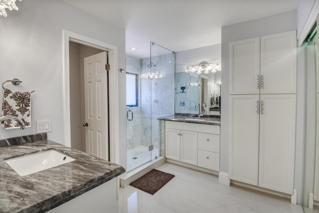 bathroom featuring an inviting chandelier, vanity, and an enclosed shower