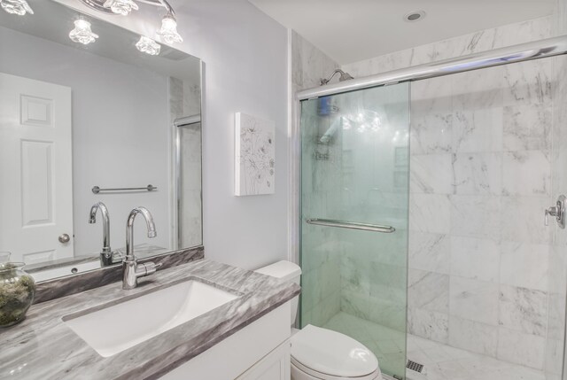 bathroom featuring vanity, toilet, and a shower with door