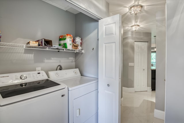 laundry area with separate washer and dryer and light tile patterned floors