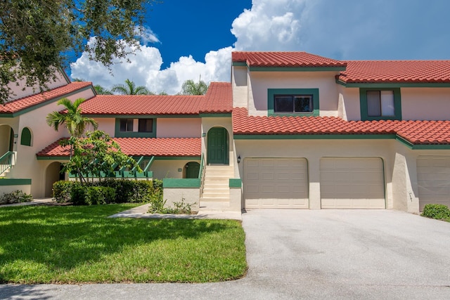 mediterranean / spanish-style house with a front yard and a garage