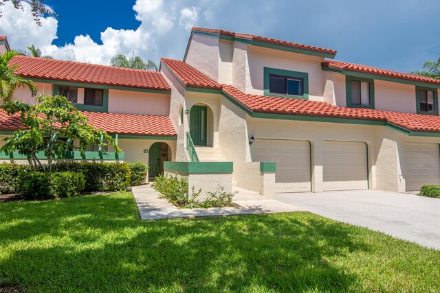 mediterranean / spanish-style home featuring a garage and a front lawn