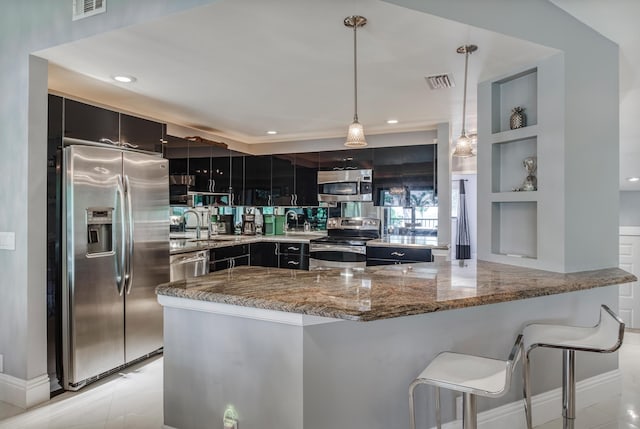 15 Lexington Ln E Unit G, Palm Beach Gardens, FL 33418 - kitchen with stainless steel appliances, light stone counters, dark cabinets, decorative light fixtures, and a breakfast bar