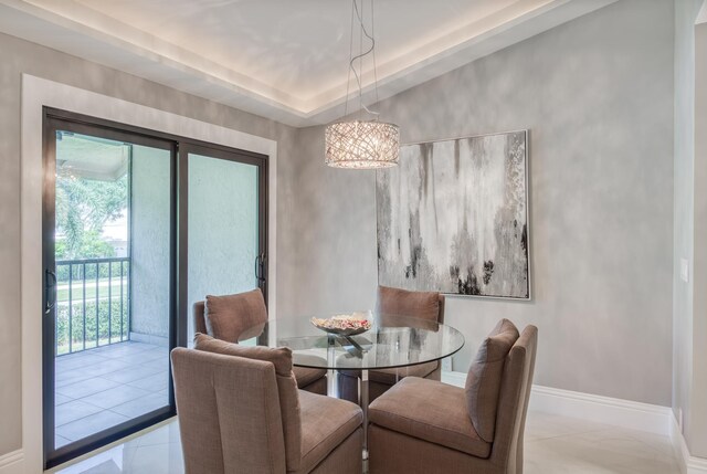 dining area featuring a notable chandelier and a raised ceiling