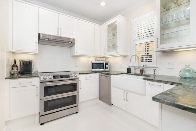 kitchen with white cabinets, appliances with stainless steel finishes, and tasteful backsplash