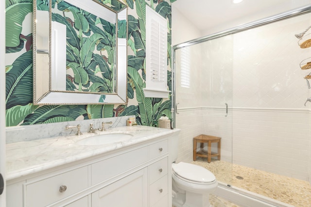 bathroom with an enclosed shower, vanity, and toilet