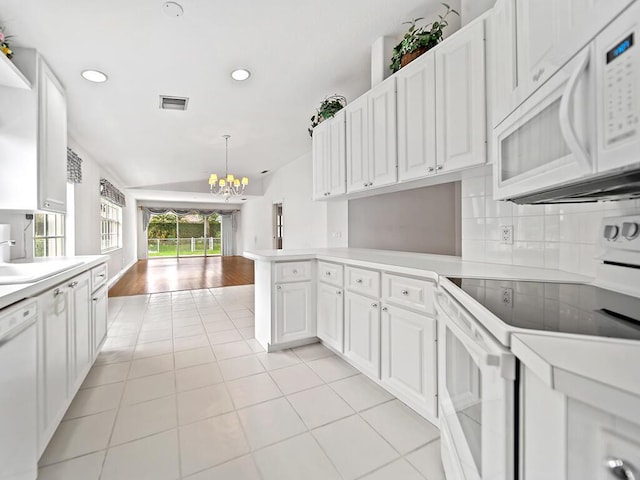 kitchen with pendant lighting, white appliances, white cabinets, light tile patterned floors, and kitchen peninsula