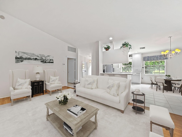 living room featuring a notable chandelier and lofted ceiling