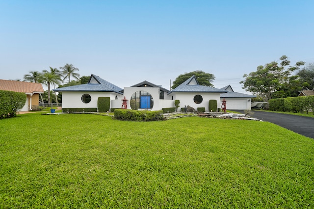 view of front of home with a front yard and a garage