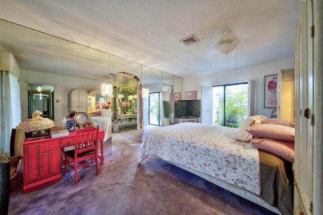 bedroom featuring ceiling fan, a textured ceiling, and carpet floors