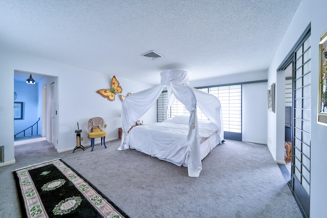 carpeted bedroom featuring a textured ceiling