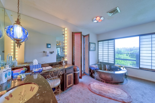 bathroom with vanity, a bathing tub, and a textured ceiling