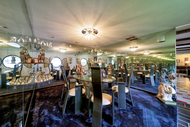 carpeted dining space featuring a textured ceiling and bar