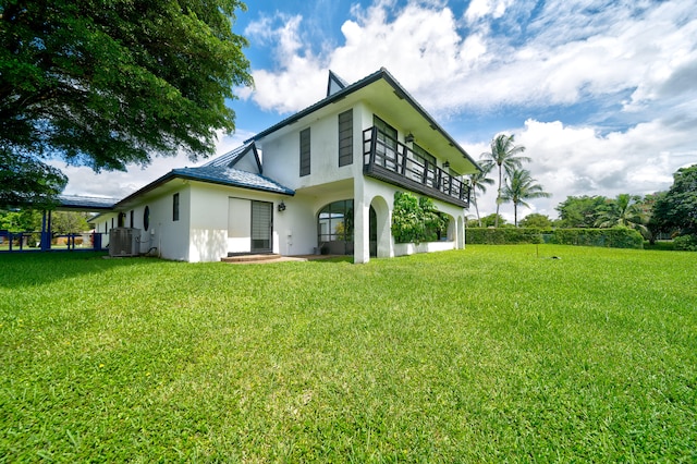 back of house featuring a lawn and central air condition unit