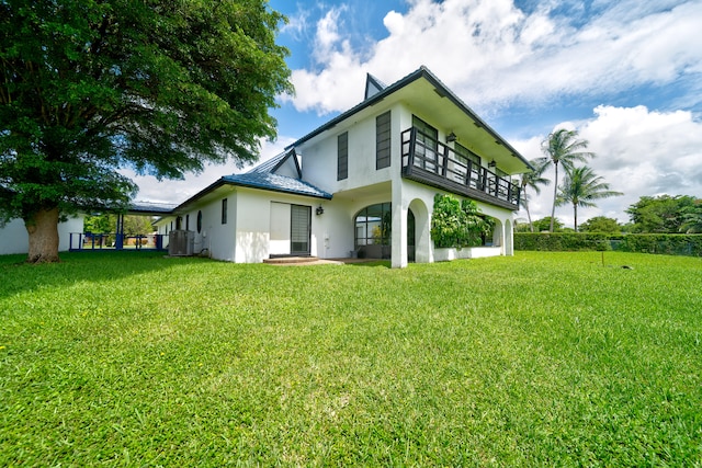 rear view of house with a lawn and central AC