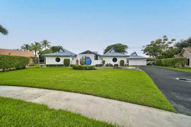 ranch-style home featuring a garage and a front yard