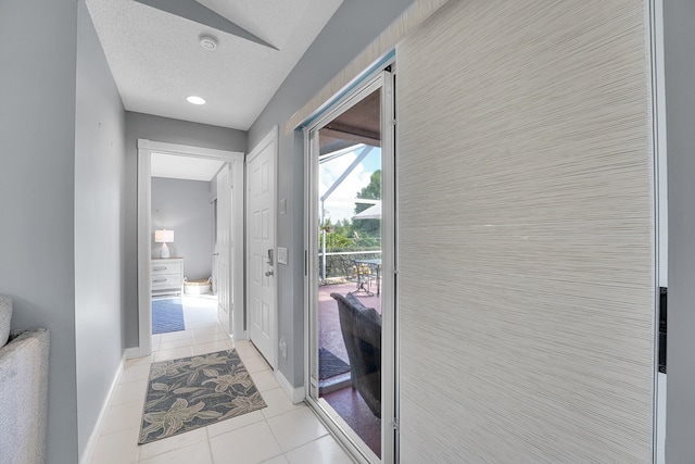 entryway with light tile patterned flooring, tile walls, and a textured ceiling