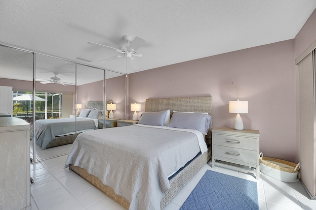 bedroom featuring ceiling fan, a textured ceiling, and light tile patterned floors