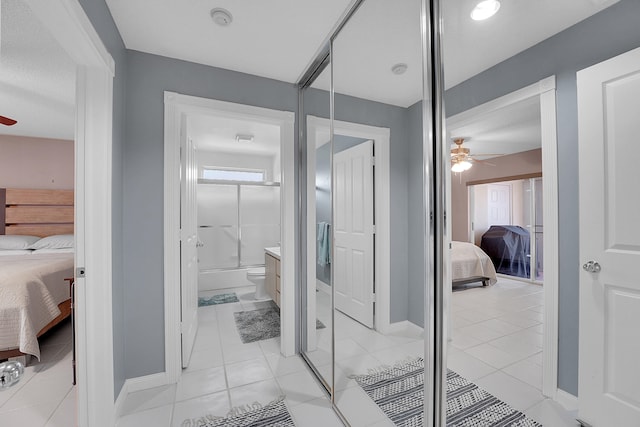 bathroom featuring ceiling fan, toilet, an enclosed shower, and tile patterned floors