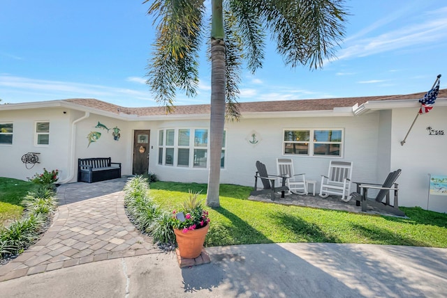 view of front of house with a patio and a front yard