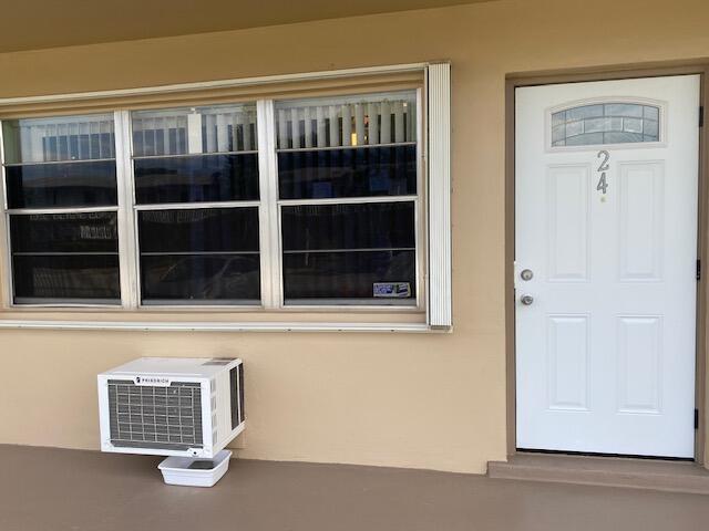 view of exterior entry with a wall unit AC