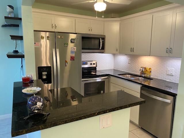 kitchen with white cabinetry, ceiling fan, appliances with stainless steel finishes, and sink