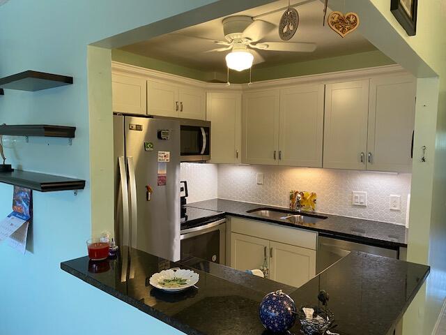 kitchen featuring white cabinets, ceiling fan, sink, and stainless steel appliances