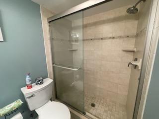 full bath with a stall shower and toilet