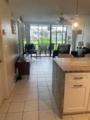 kitchen with ceiling fan, light countertops, light tile patterned floors, and floor to ceiling windows