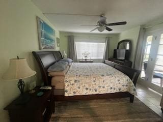 tiled bedroom featuring multiple windows and ceiling fan